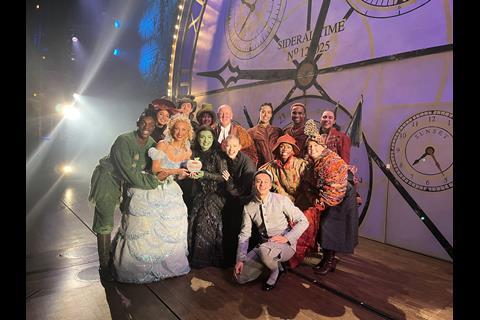 The West End cast of Wicked pose with their School Travel Award on stage at the Apollo Victoria Theatre